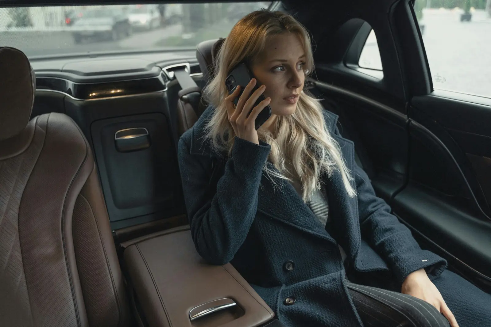Passenger on the phone in the back seat of a chauffeured luxury sedan in Chicago