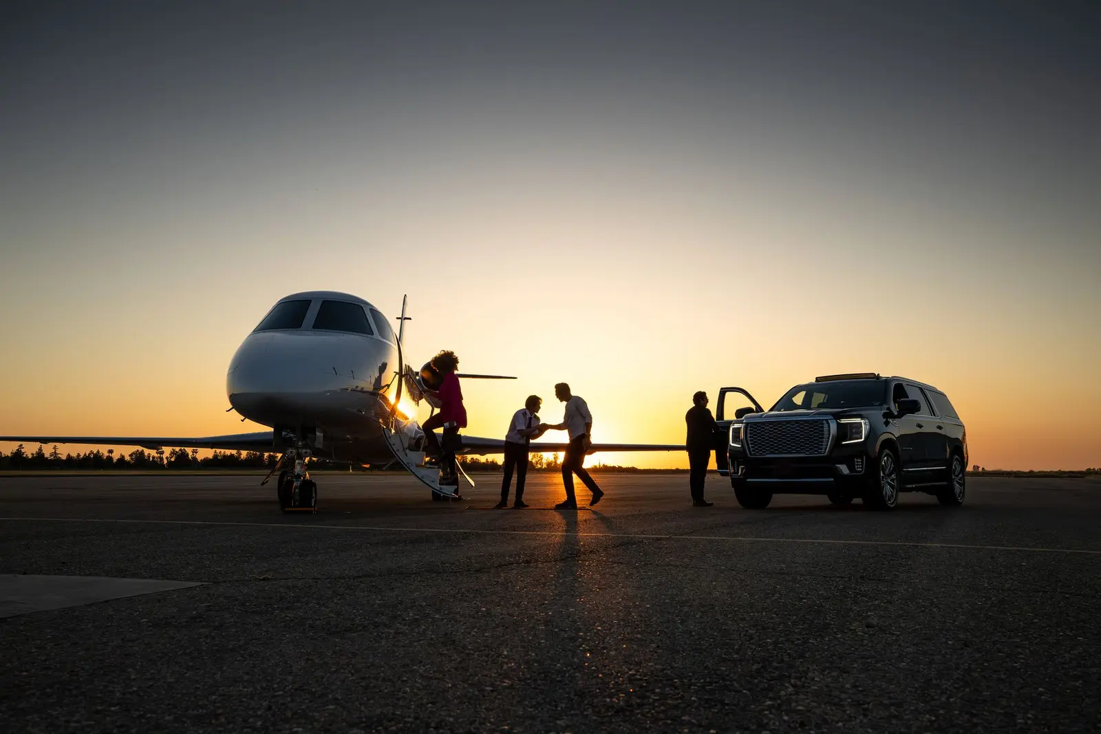 Business professionals meeting beside a chauffeured vehicle